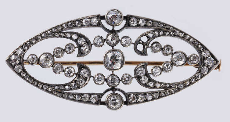 Брошь из желтого и белого металла, общим весом 7,82 грамма, содержит природные вставки из бриллиантов